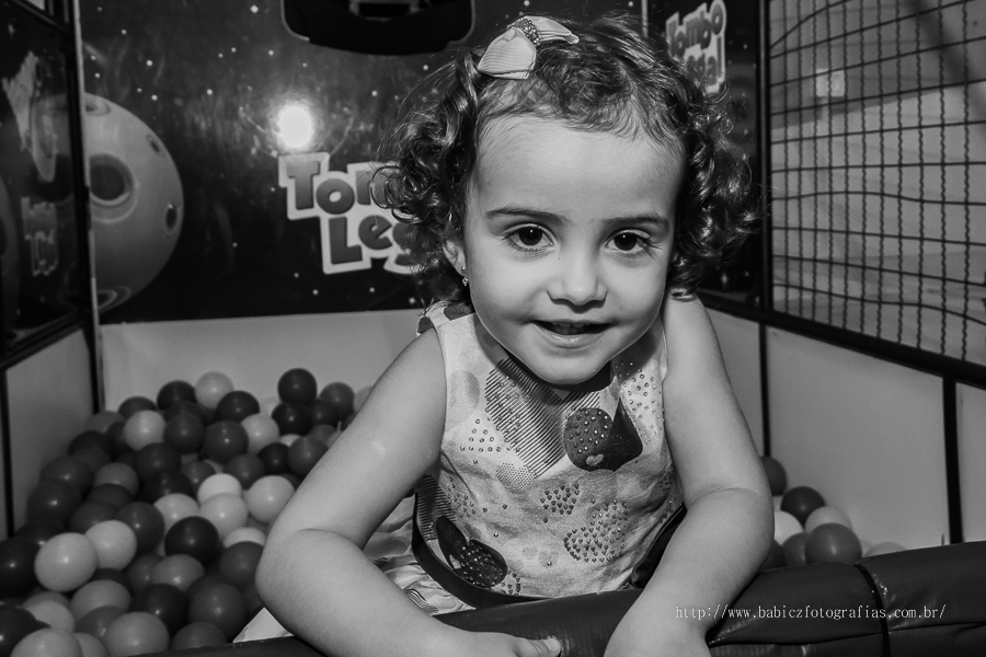 Fotografia da aniversariante brincando na piscina de bolinha 