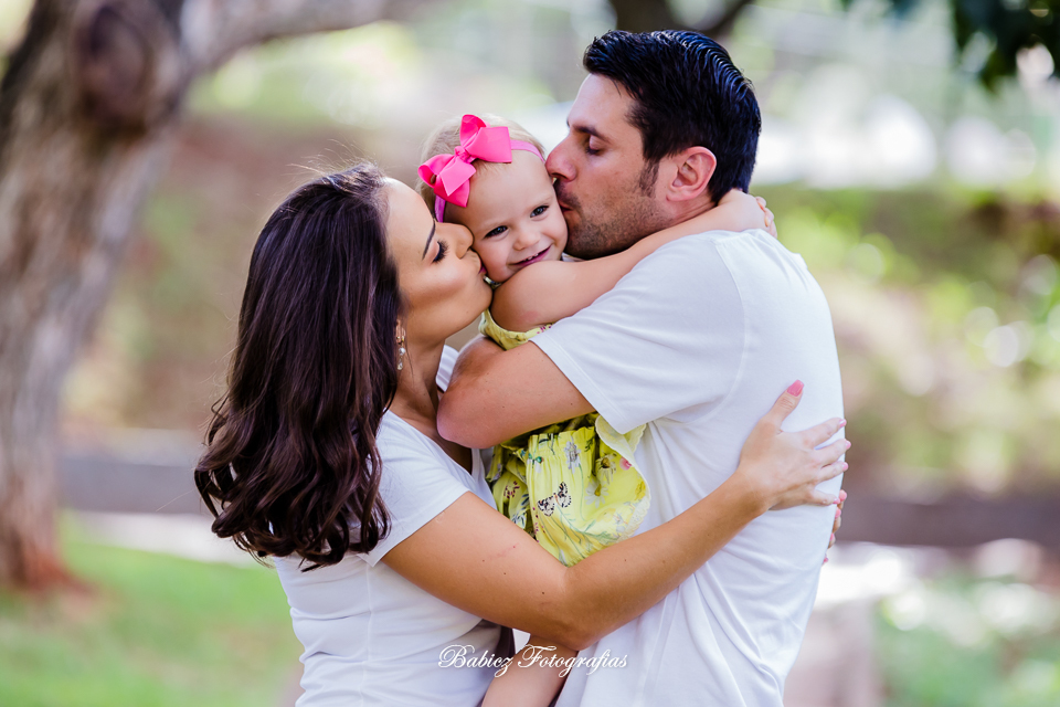 Fotografia de abraco com papai e mamae da Alice no ensaio lindo do book de pre-aniversario infantil