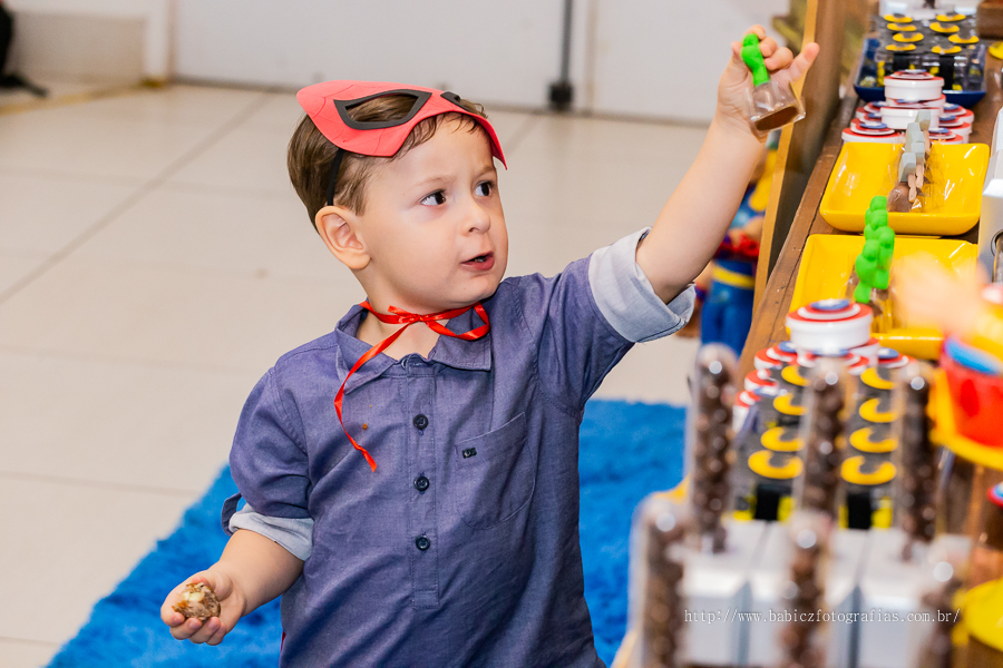 Fotografia do aniversariante brindo, sua festa com decoração da liga da justiça e vingadores no Jungle Frends em Maringá.