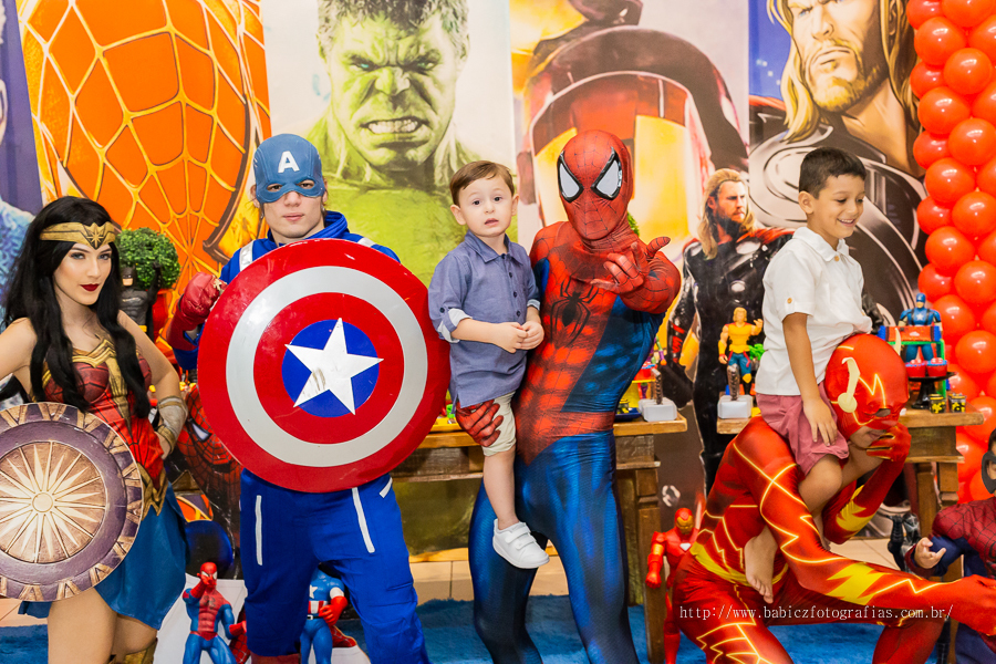Fotografia do aniversariante Théo com os pais junto com os personagens da liga da justiça e vingadores no buffet Jungle em Maringá. 