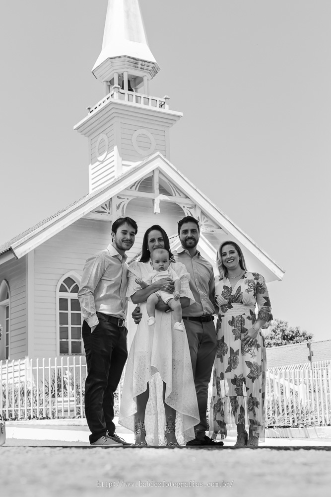 Fotografia de batizando de manha com os pais e padrinhos na frente da capela Madre Paulina