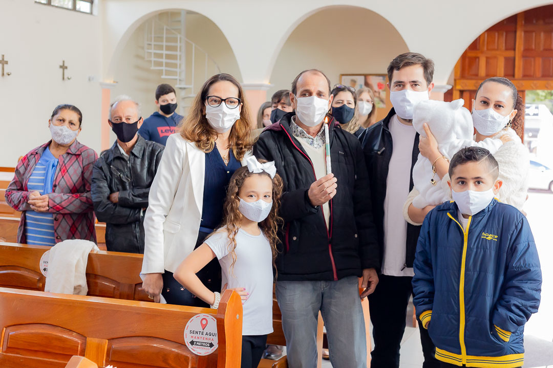 Foto da família durante o batizado com a vela