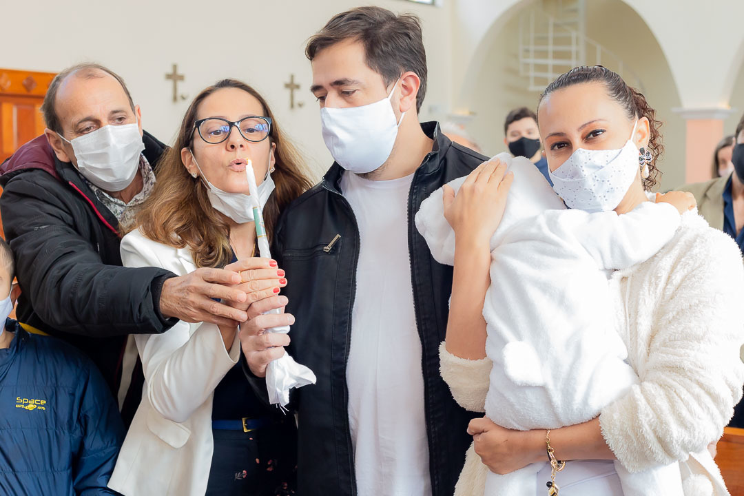Foto da família durante o batizado com a vela
