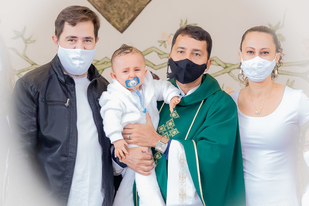 Foto da família durante o batismo com o Pároco Pe. Adacílio Félix de Oliveira