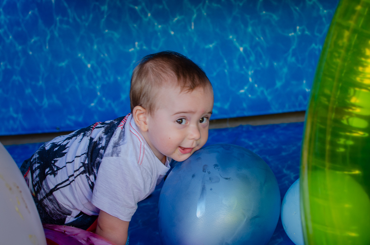 Zemar Fotografia - Festa de aniversário de 01 ano - Criança brincando com balão e com o rosto apoiado no balão