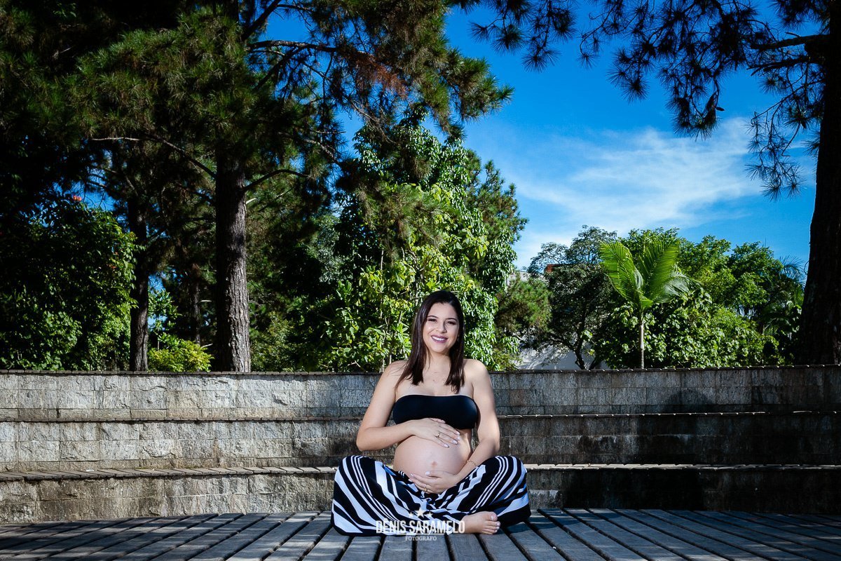 Tamires sentada da UFJF durante seu ensaio fotográfico de gestante