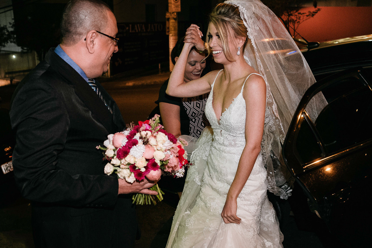 noiva sai do carro e pai segura seu buque