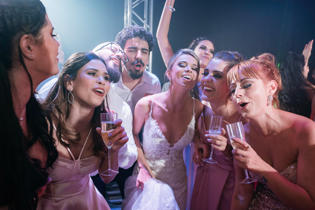 amigos cantam junto com a noiva em festa de casamento animada
