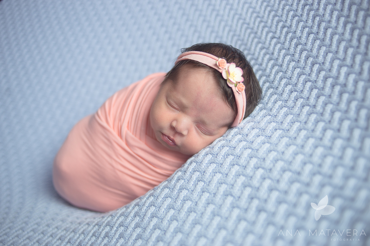 Bebê enroladinho no wrap em ensaio newborn a domicílio