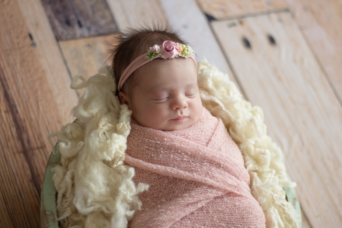 Foto de perfil de bebê em ensaio fotográfico newborn no cestinho