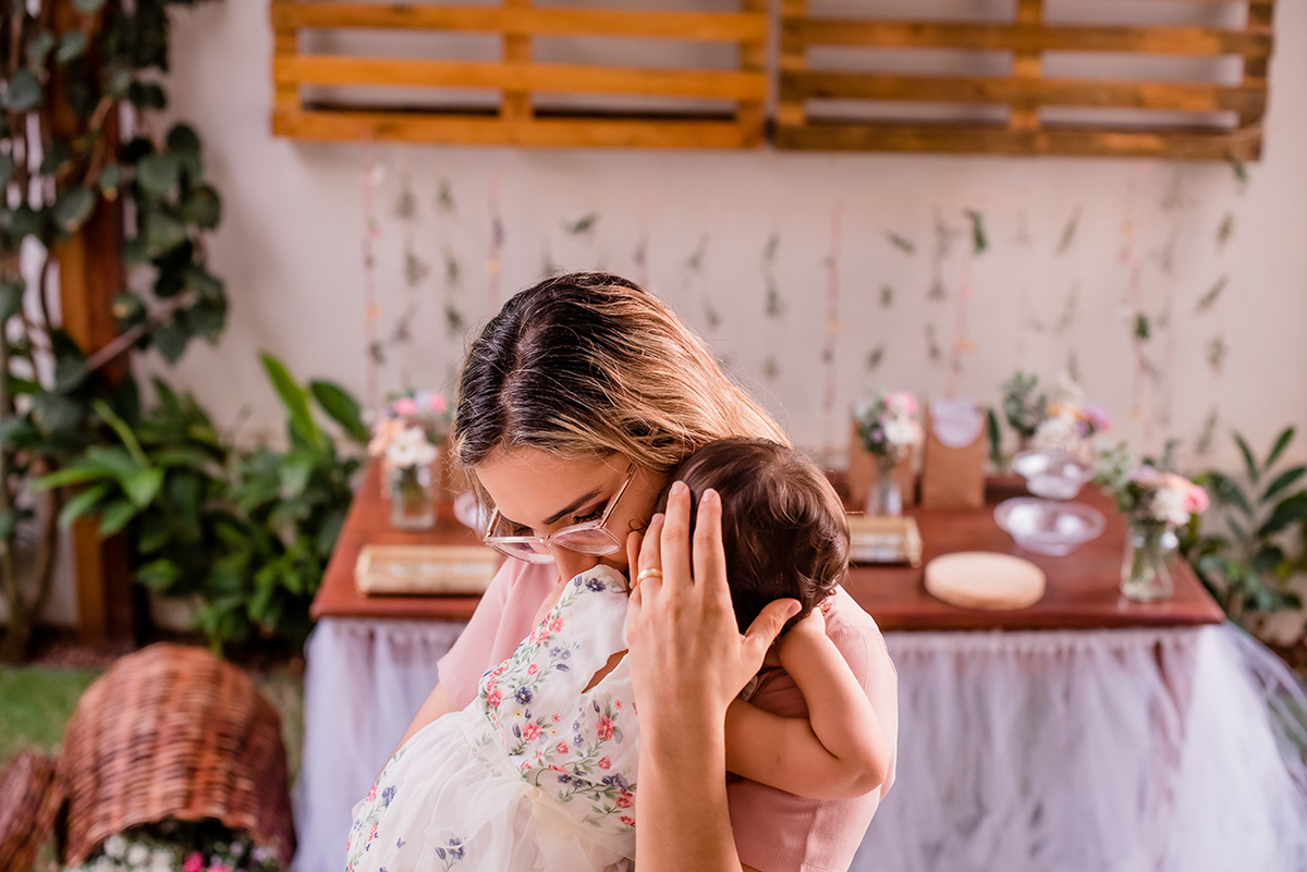 Mãe abraçada com filha que faz um ano de idade