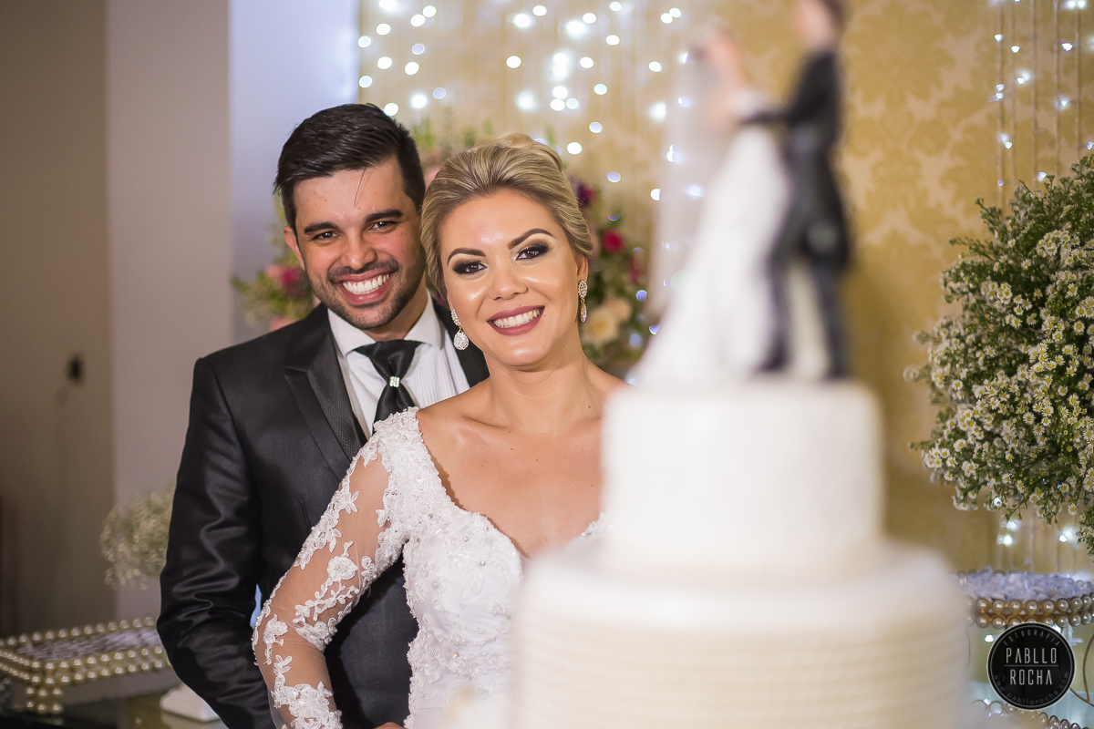 noivos passando para fotos na mesa do bolo