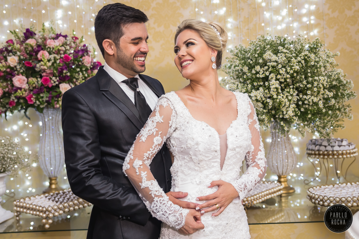 noivos passando para fotos na mesa do bolo