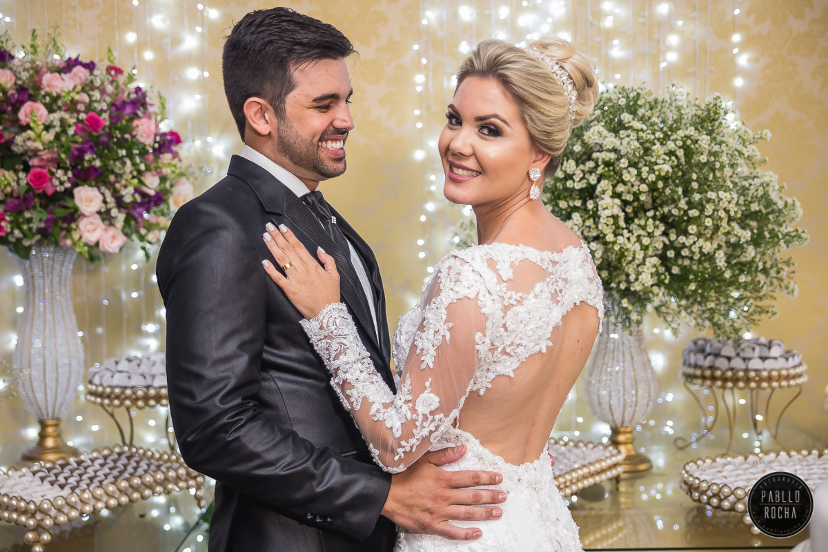 noivos passando para fotos na mesa do bolo