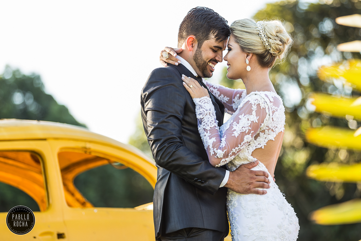 noivos posando para fotos  ao lado de um fusca amarelo