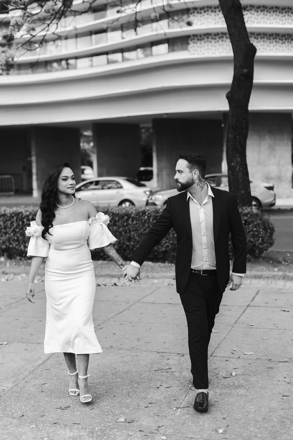 Casal de mãos dadas caminhando na Praça da Liberdade