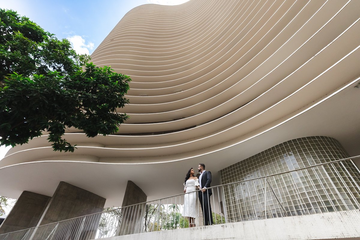 Casal em frente à arquitetura moderna da Praça da Liberdade