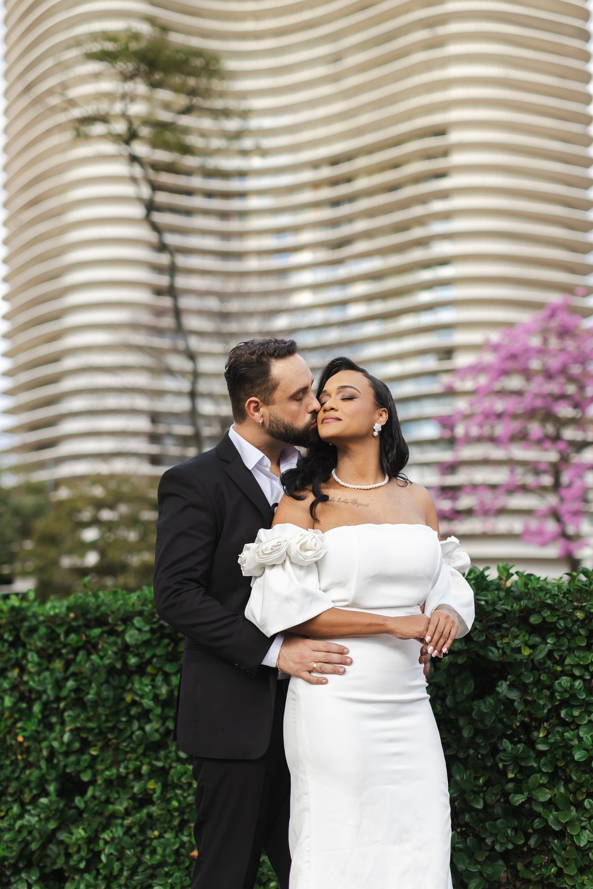 Retrato do casal com os prédios de BH ao fundo na Praça da Liberdade