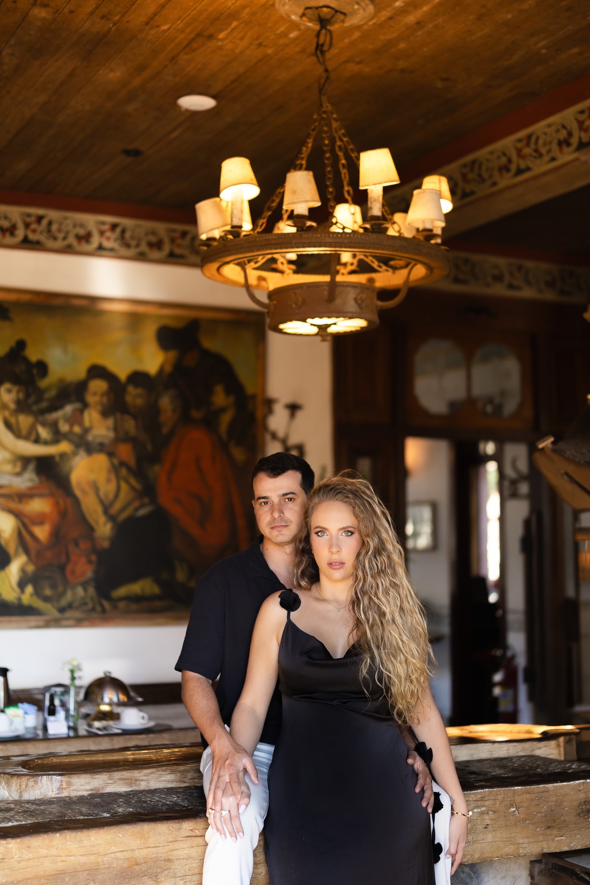 Casal sentado à mesa, no ambiente interno decorado do hotel