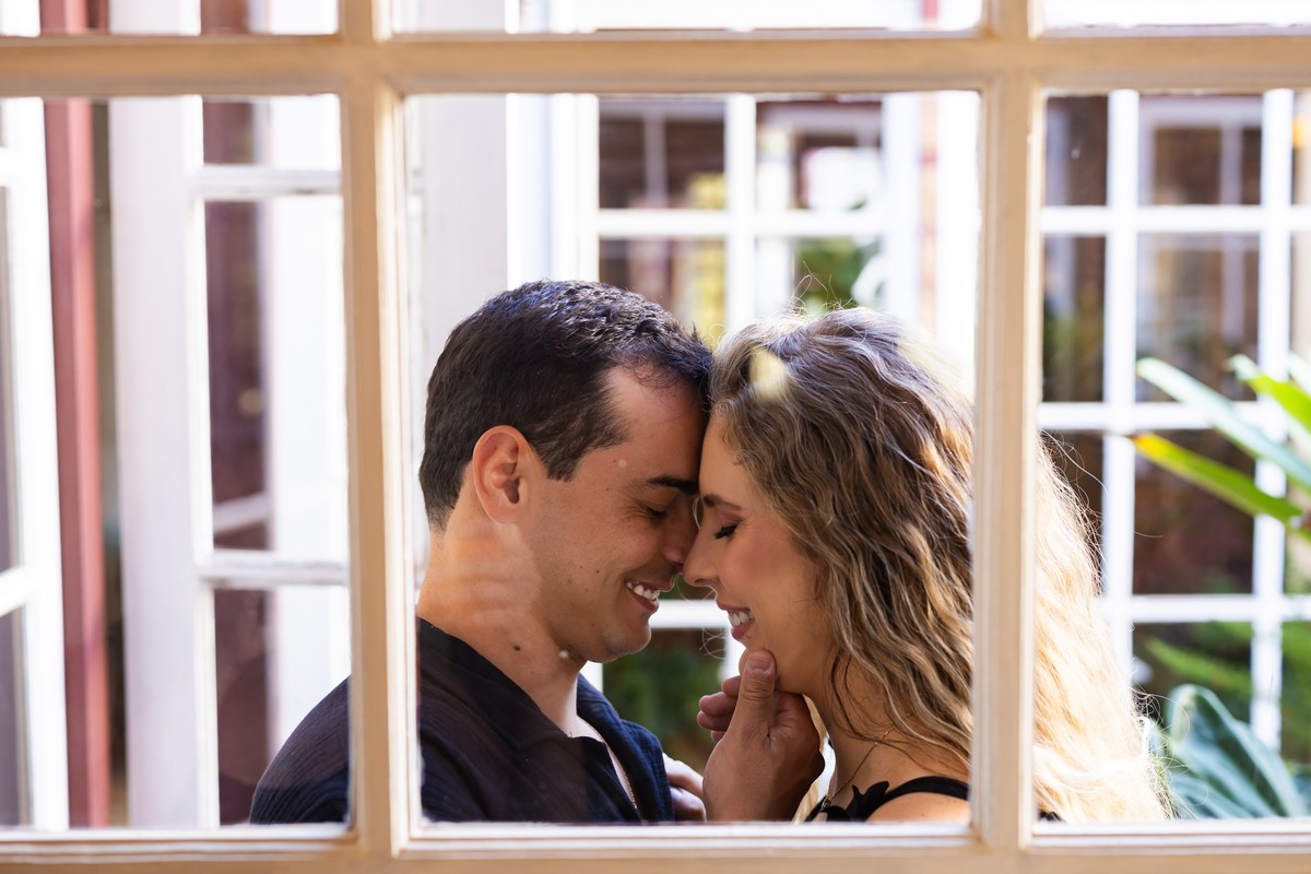 Casal se beijando próximo à janela