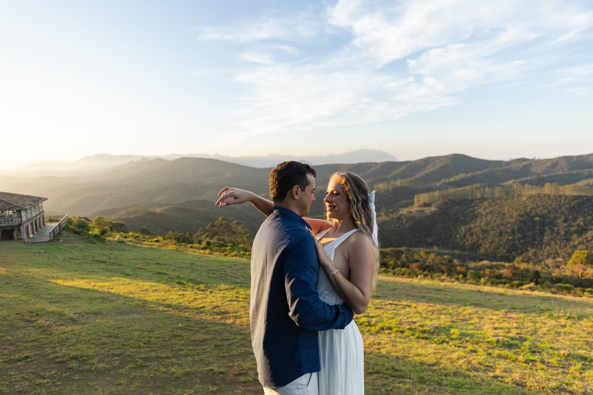 Casal se abraçando com vista panorâmica de Ouro Preto ao fundo