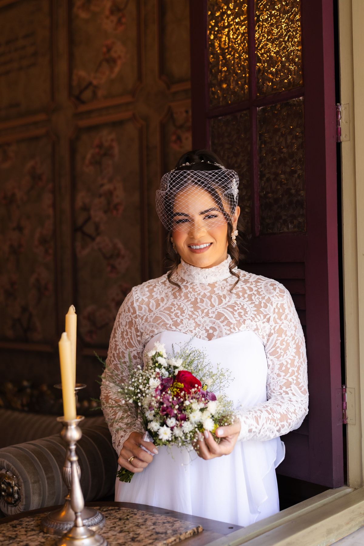 Noiva com vestido vintage e casquete com buquê de flores em ensaio pré-casamento