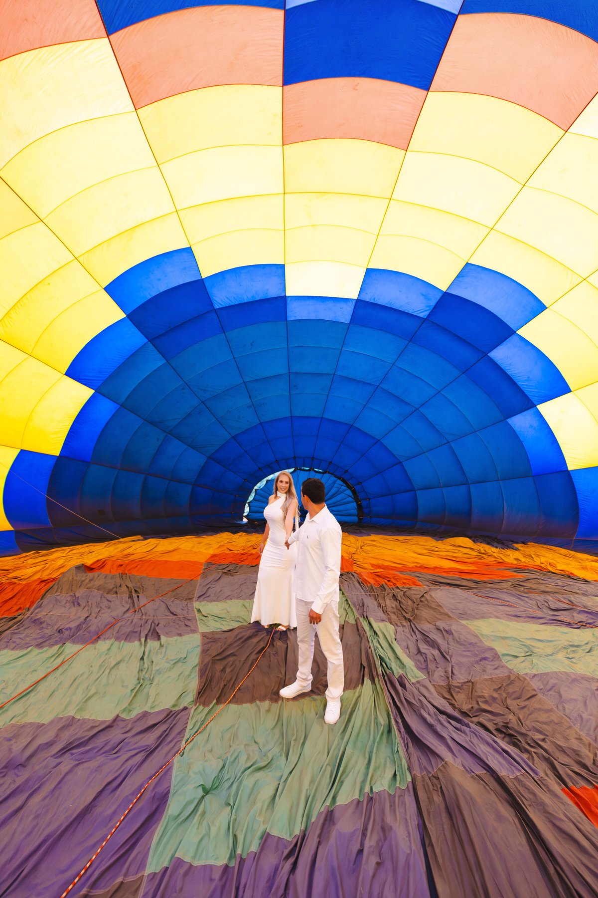 Casal em pé dentro do balão de ar quente colorido no pré-wedding