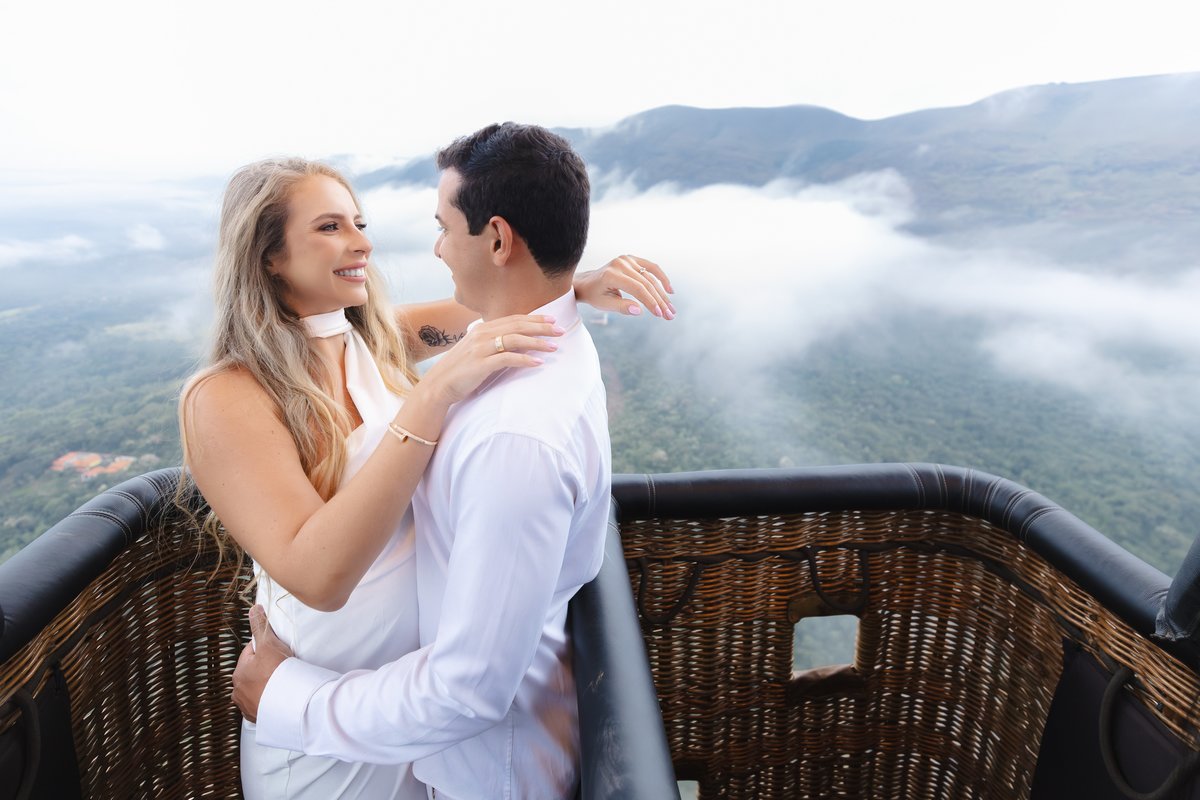 Casal dentro do cesto de balão voando sobre as montanhas de Minas Gerais