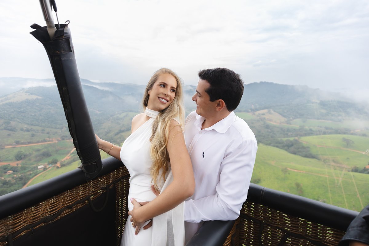 Casal sorrindo e aproveitando a vista no passeio de balão em Brumadinho