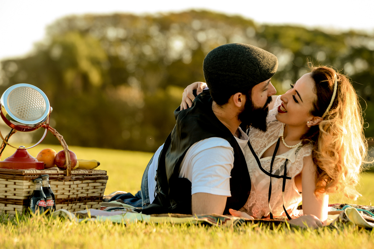 ensaio retro casal com estilo unico com coisas antigas no cenário como radio antigo garrafa de coca-cola com um gramado verde feito na plantação de feno em Holambra cidade das flores 