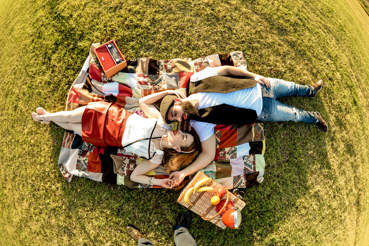 ensaio retro casal com estilo unico com coisas antigas no cenário como radio antigo garrafa de coca-cola com um gramado verde feito na plantação de feno em Holambra cidade das flores 