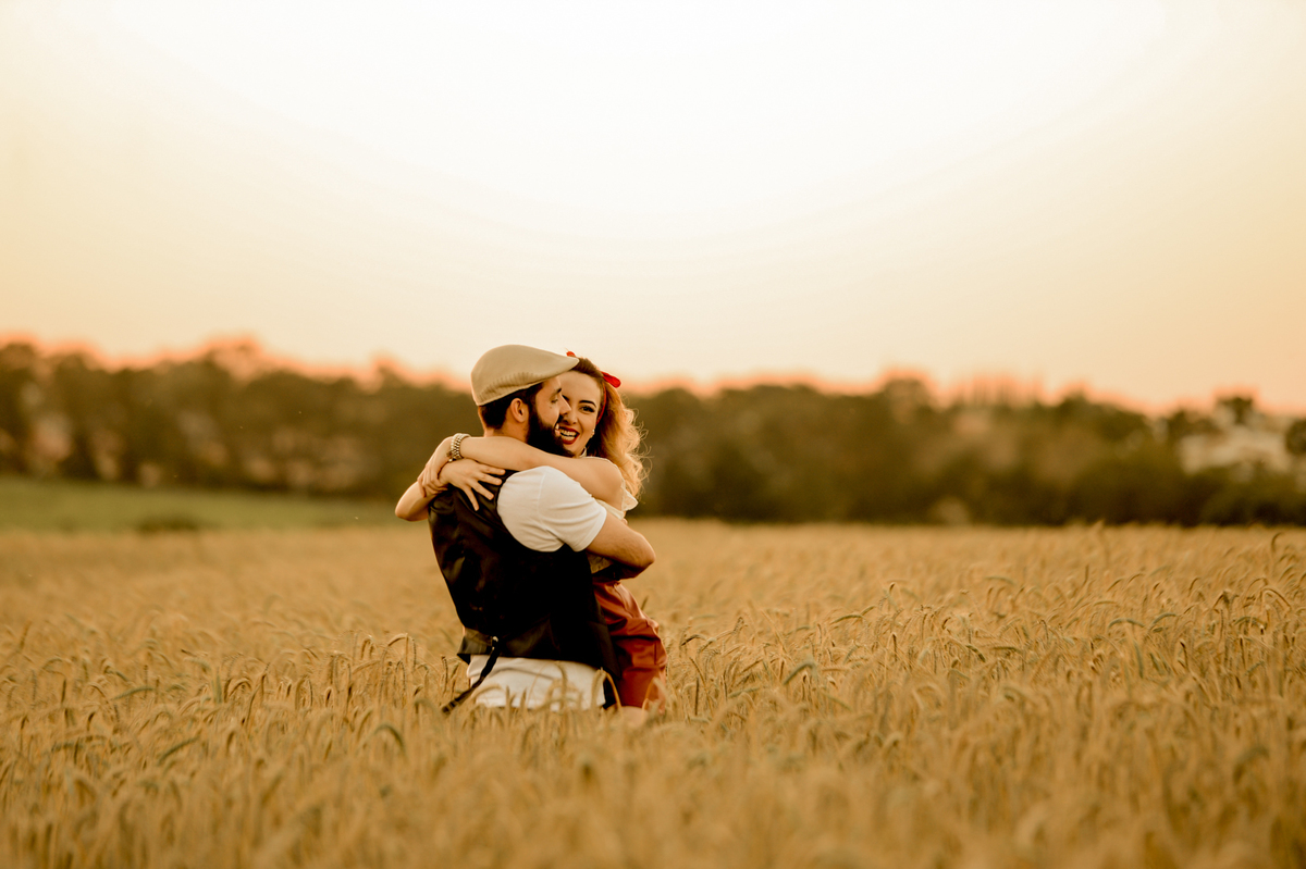 casal junto no ensaio de pre-wedding em uma plantação de trigo feita no por do sol em Holambra cidade das flores 