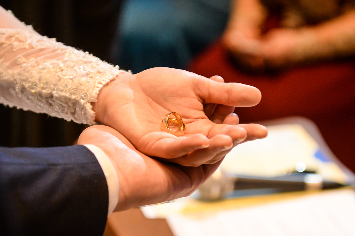 momento da benção das alianças detalhes pegando somente as maos e as alianças 