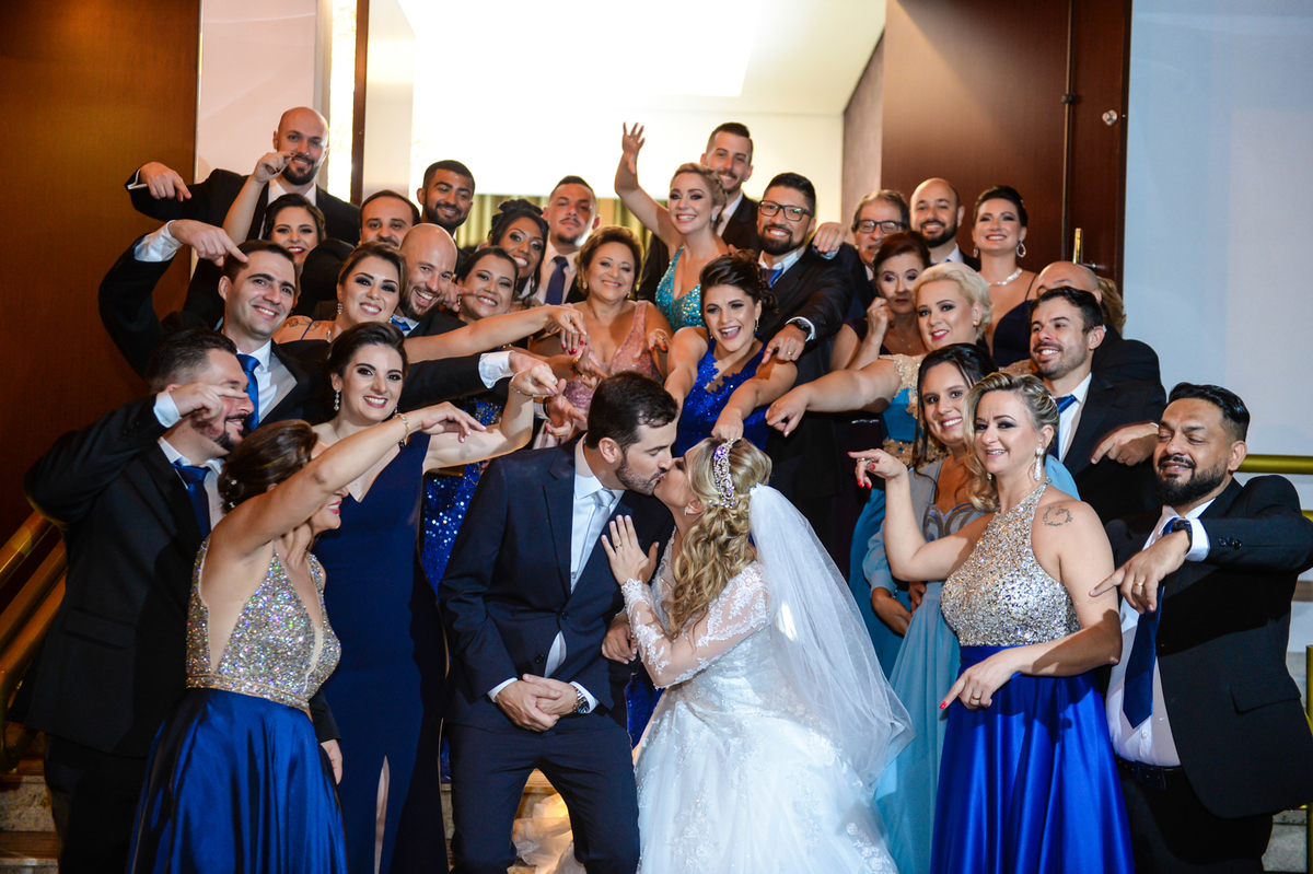 aquele beijo dos noivos na saida da cerimonia com todos os padrinhos ao lado apontando para eles 