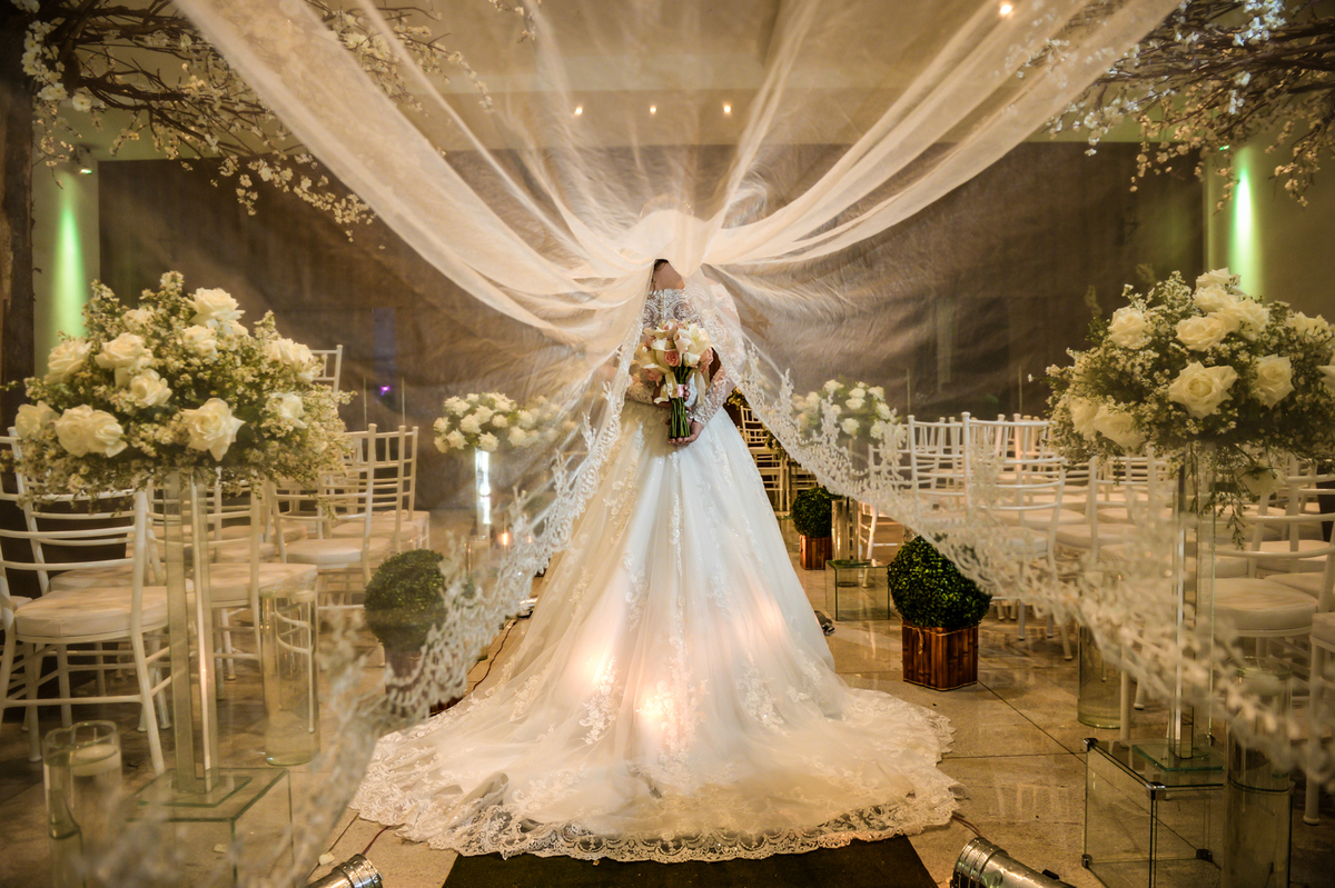 aquele vestido de noiva maravilhoso e seu veio ao alto com a noiva segurando um buque de flores naturais 