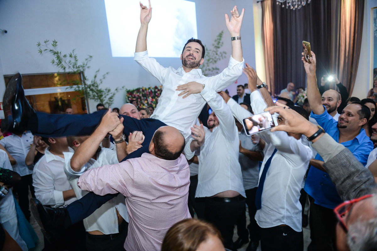 amigos jogando o noivo para o alto na hora da festa todos animadas 