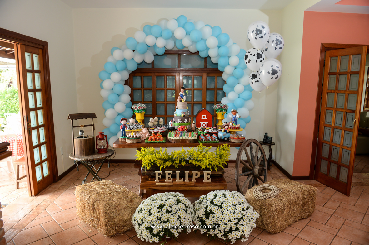 mesa toda decorada com balões e feno na frente e muitos doces
