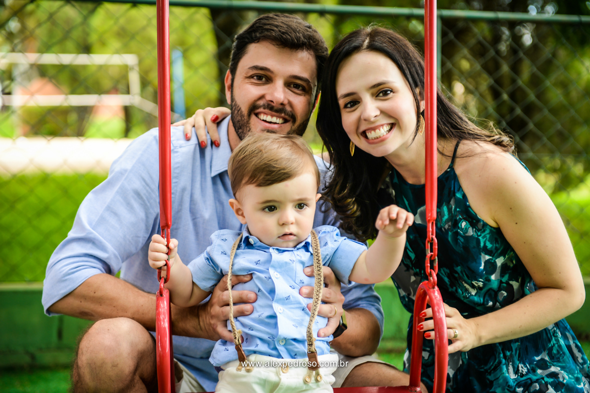 pai filho e mae todos sorridentes brincando na balança colorida momento bem descontraído