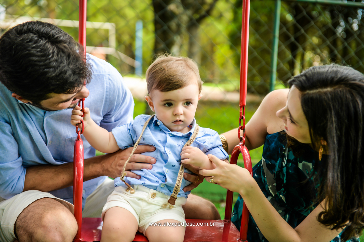 pai filho e mae todos sorridentes brincando na balança colorida momento bem descontraído