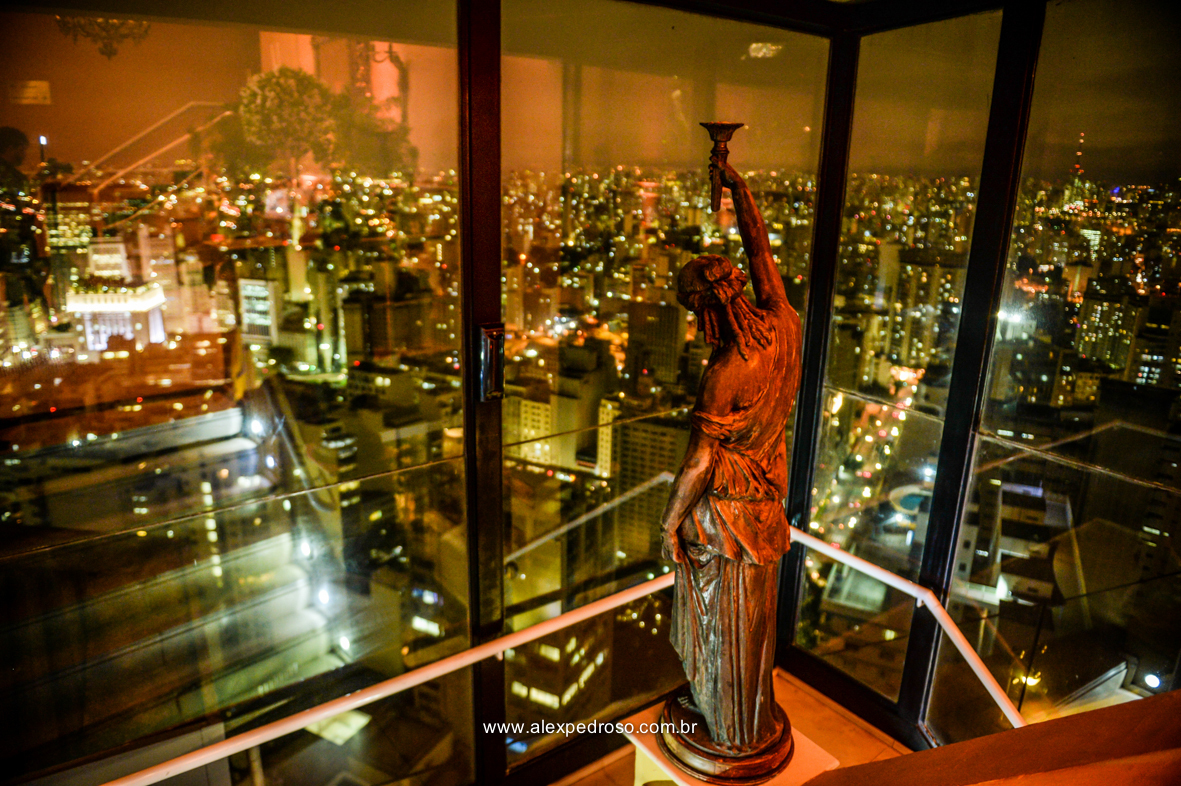 foto da estatua virada para cidade de sao paulo   do restaurante Terraço Italia com a visão a noite da cidade de sao paulo que fico no predio circulo Italiano no centro de sao Paulo onde se tem a vista de sao paulo 