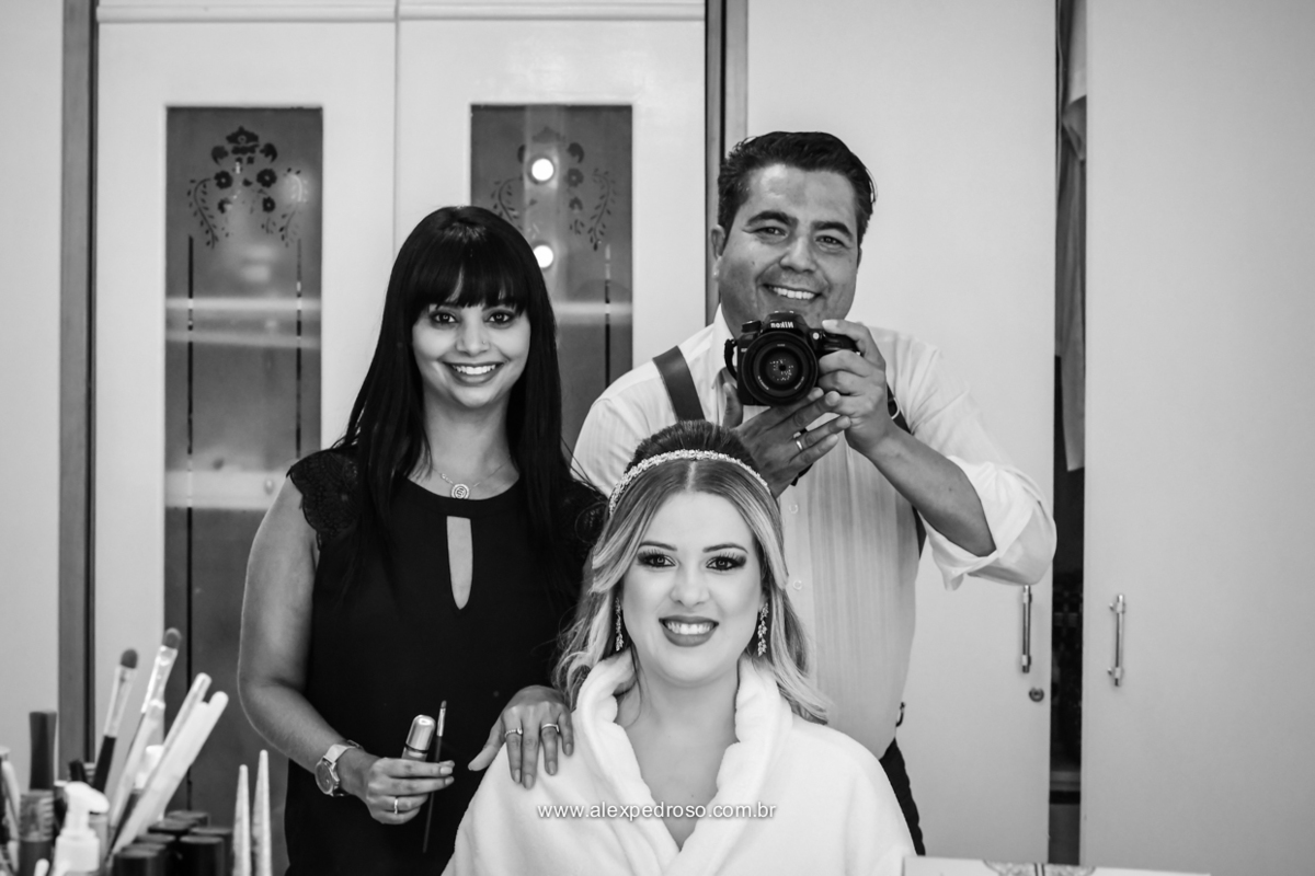 foto preto e branco da maquiadora junto com a noiva e o fotografo 