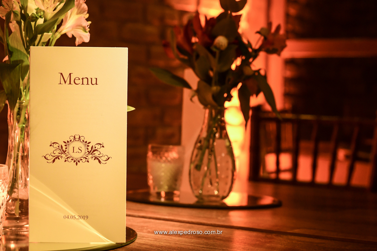 cardápio personalizado na mesa com arranjo de flores ao fundo espaco flores na varanda 