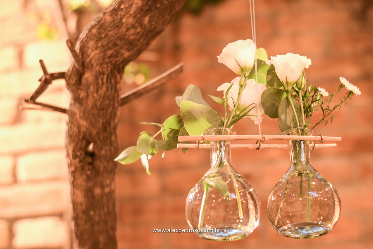 arranjo com vazo transparente e flores com decoração suspensa 