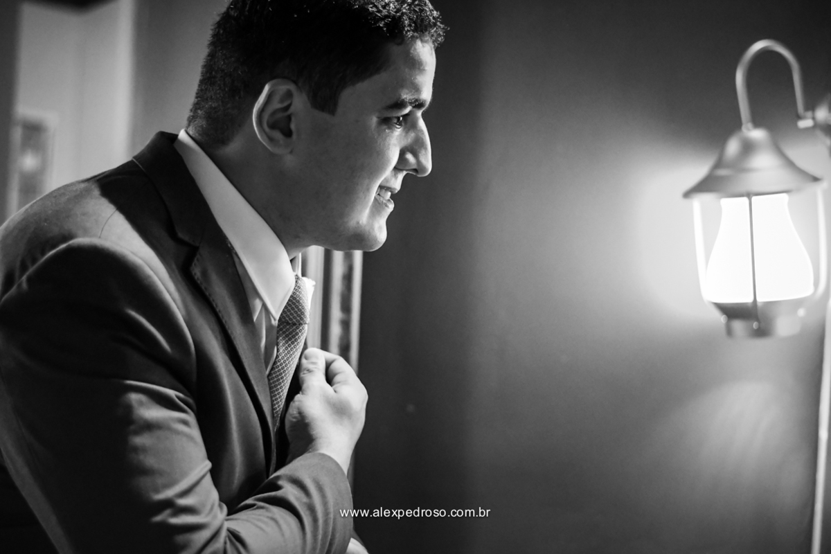 finalizando detalhes da gravata ja de terno com um luz de fundo 