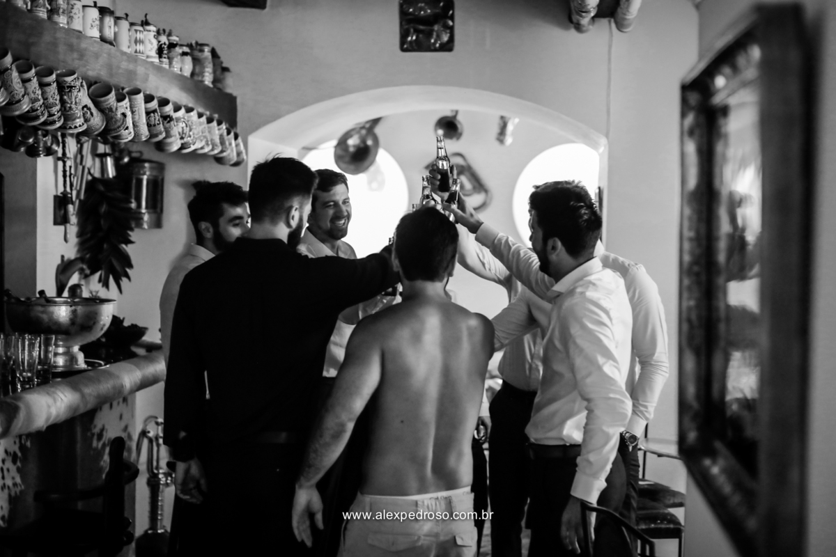 noivo junto com os padrinhos e amigos queridos fazendo um brinde com cerveja foto feita em preto e branco