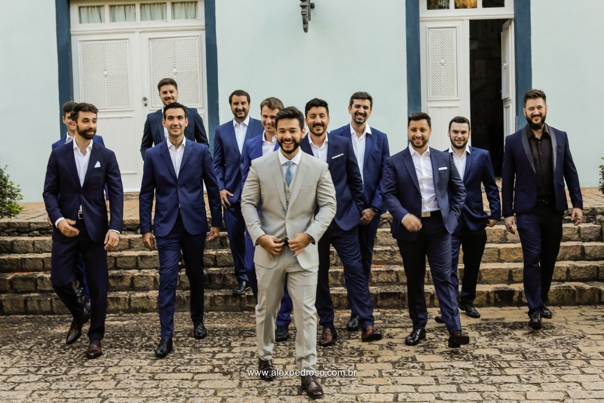 noivo de terno claro com os padrinhos de terno azul indo para cerimonia