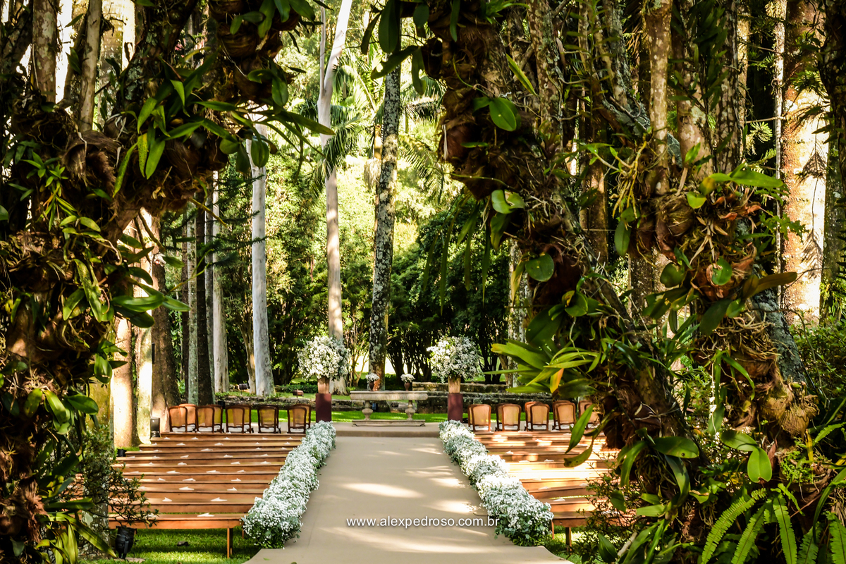local da cerimonia fazenda vila rica com os bancos de madeira um corredor coberto por um tapete de palha e decoracao feita com flores