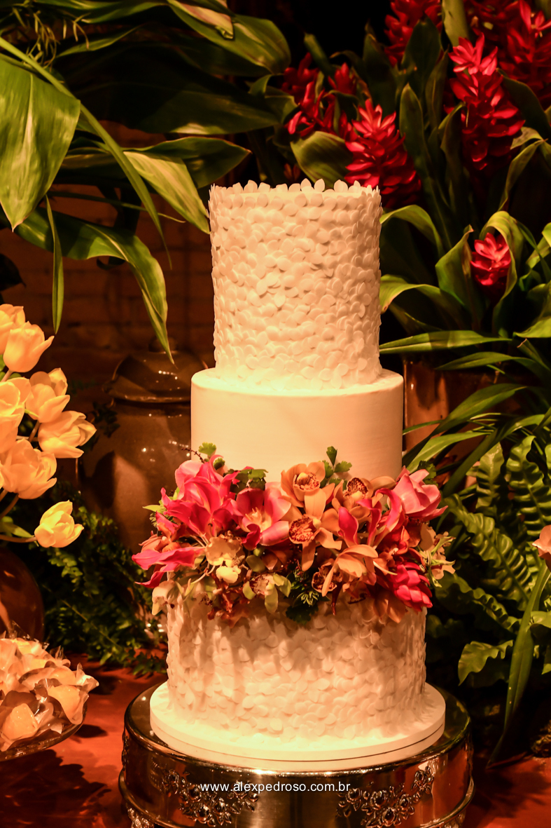 bolo de casamento decorado com flores com uma iluminação senica