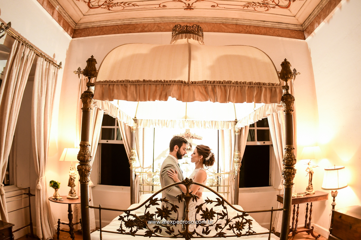 casal ajoelhado na cama antiga com uma luz entrando por tras