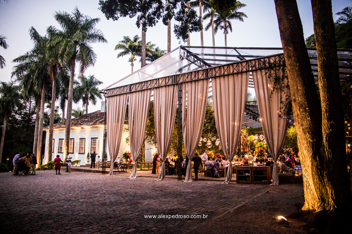 fachada da parte da festa toda decorada com cortinas e o casarão da fazenda vila rica  ao fundo